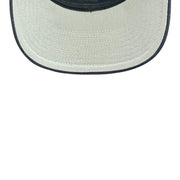 Close-up of a straw hat with a navy rim on a white background