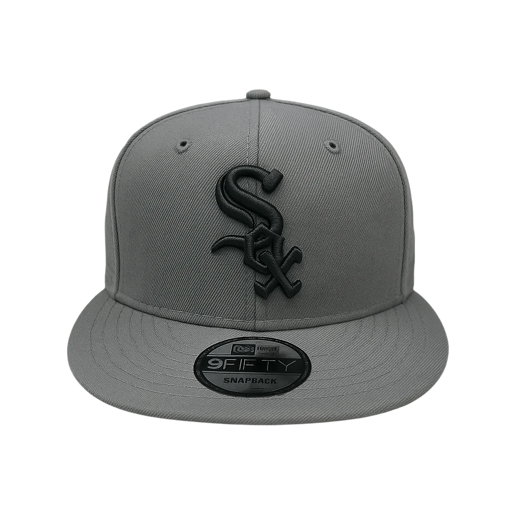 A front-facing view of a Chicago White Sox snapback hat in dark graphite color with a black embroidered "Sox" logo and a visible New Era 9FIFTY sticker on the flat brim.