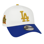 New Era 9FORTY A-Frame adjustable cap with white crown and royal blue brim, featuring a metallic gold LA logo, World Series side patch, and accurate reflective sticker on the visor.
