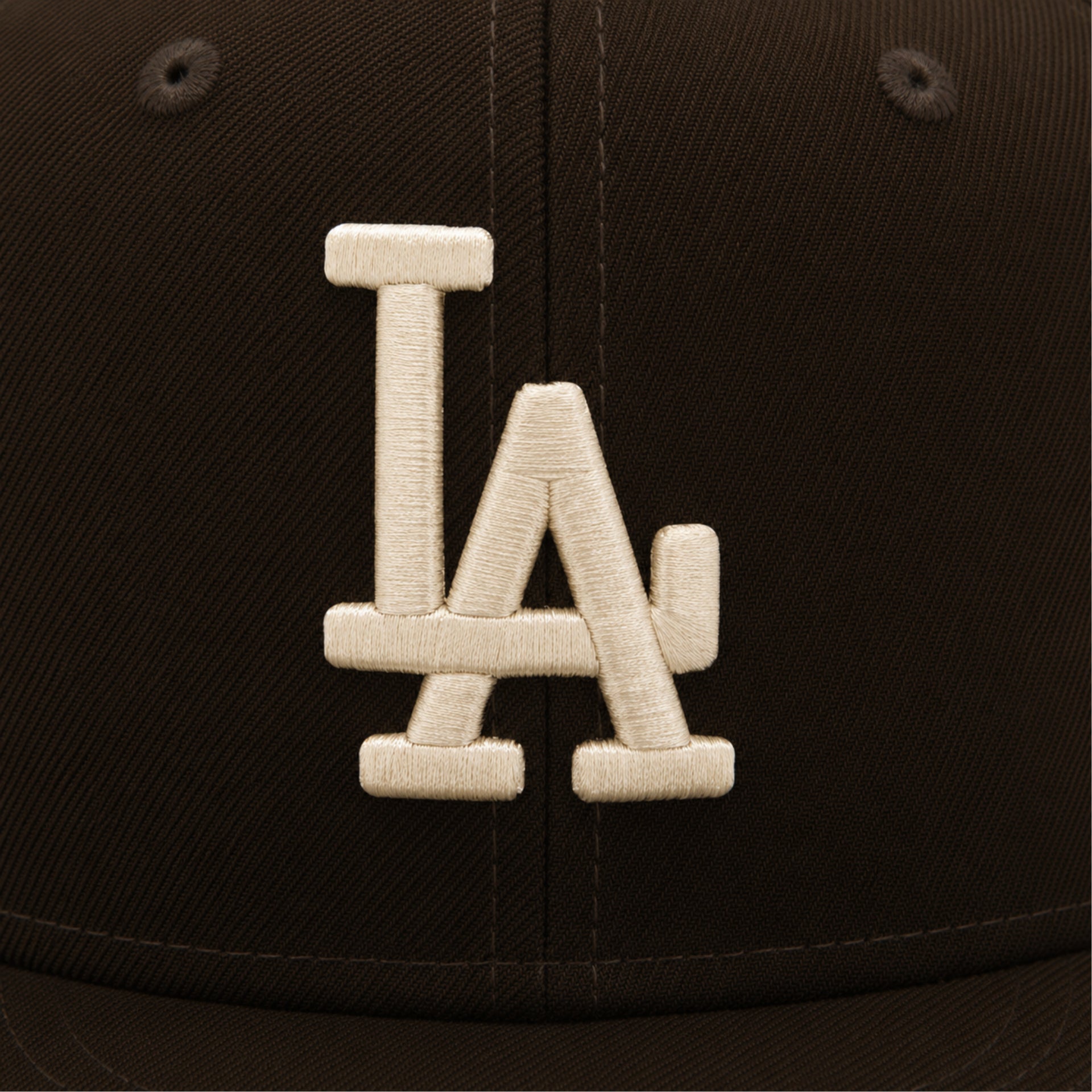 Close-up of a black cap with a white 'LA' logo on a dark background