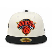 Front view of New Era New York Knicks 2026 Champions Chrome Black 59FIFTY fitted hat with orange Knicks embroidery and black flat visor