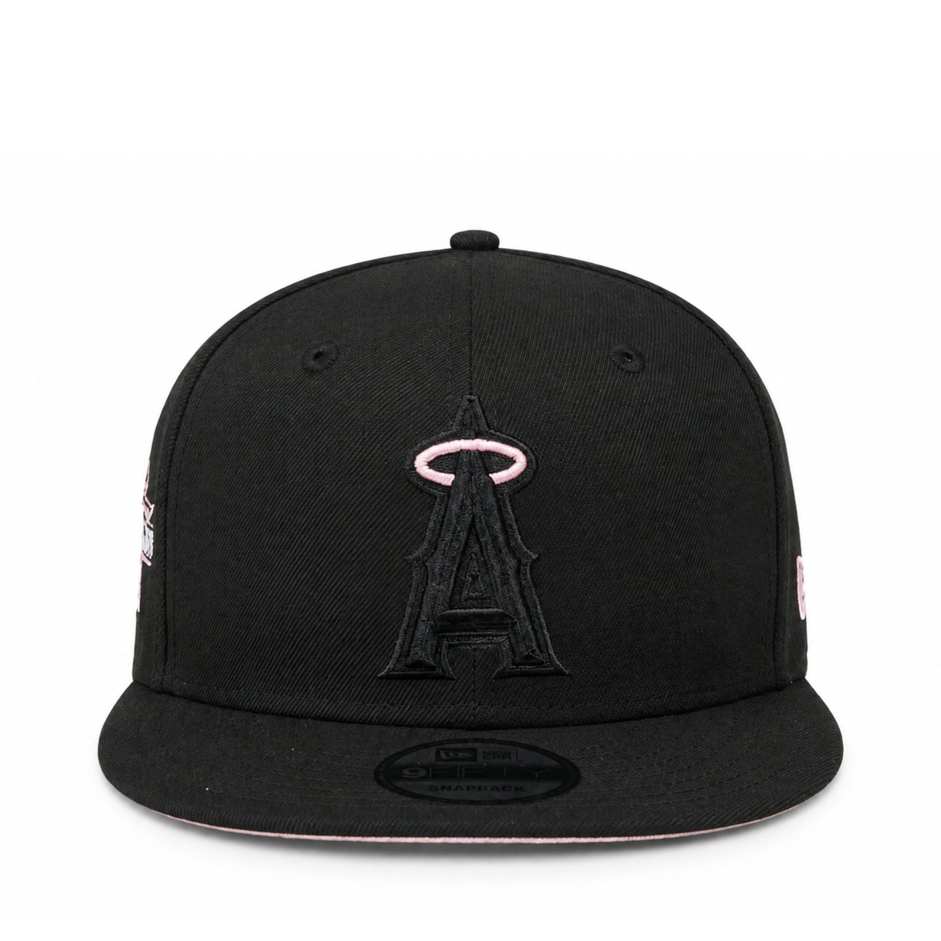 A black flat-brim baseball cap featuring an embroidered black Angels logo with a pink halo on the front, shown against a plain white background.