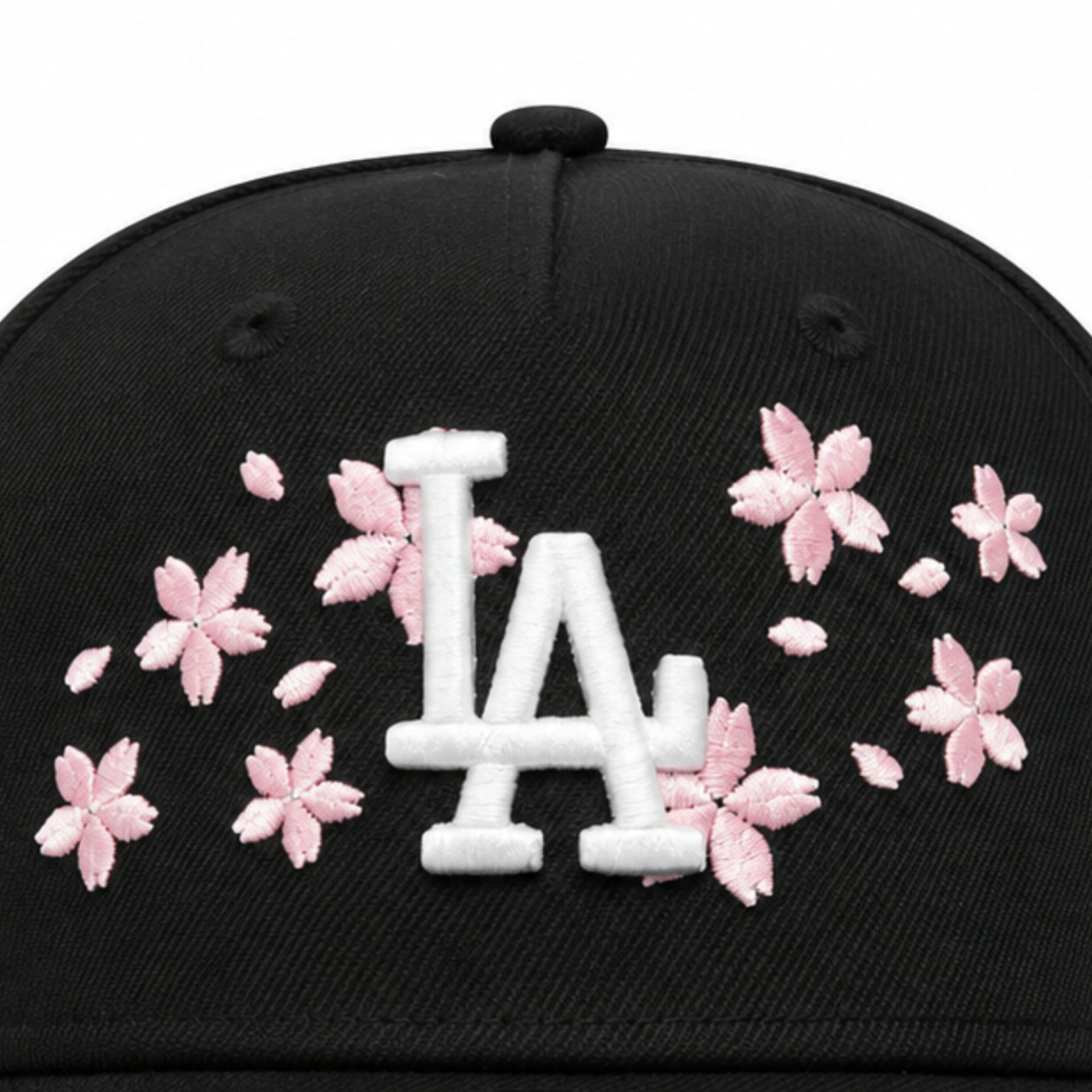 close view of New Era Los Angeles Dodgers Cherry Blossom Black 9FORTY A-Frame Snapback with white LA logo, pink cherry blossom embroidery, and pink undervisor.