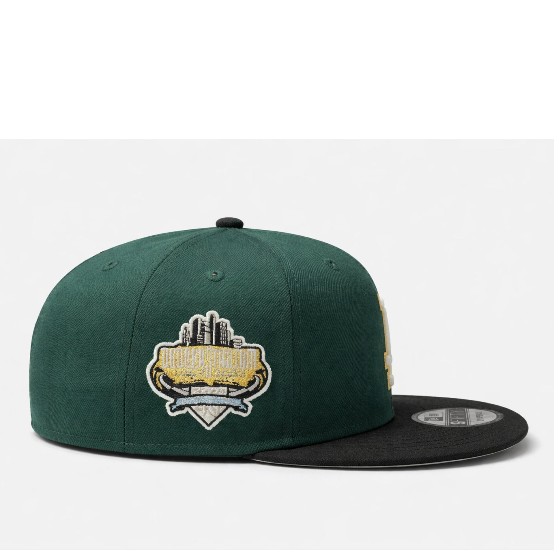 side view of Green and black baseball cap with 'LA' logo on a white background