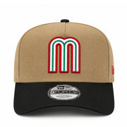 A New Era 9Forty adjustable baseball cap in tan and black, featuring a large embroidered letter 'M' patch on the front in red, white, and green.