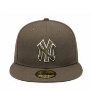 A brown New York Yankees fitted baseball cap with a camouflage-style embroidered NY logo on the front. The cap features a flat brim with a gold and black New Era 59FIFTY sticker, set against a plain white background.
