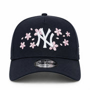 Navy blue New York Yankees NY cap with white logo and pink floral designs on a white background
