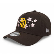 Black cap with yellow logo and pink floral designs on a white background
