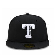 A black fitted baseball cap featuring a large white embroidered letter 'T' on the front, with a gold New Era 59FIFTY sticker on the brim, set against a plain white background.