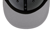 Close-up of the front of a gray and black baseball cap, showing the curved brim, black eyelets, and a vertical black band with white text reading '59FIFTY' on a white background.