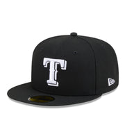 A black Texas Rangers fitted baseball cap with a white embroidered 'T' logo on the front and a white New Era logo on the side, shown on a plain white background.