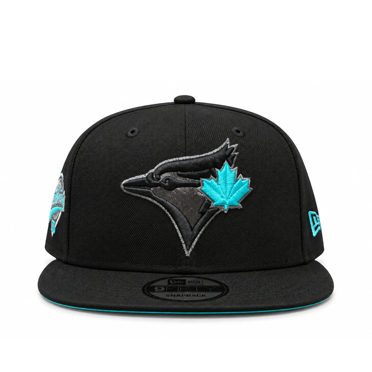 Angled front view of Toronto Blue Jays black 9FIFTY snapback featuring black embroidered bird logo, teal maple leaf and flat brim