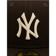 Close-up of a New York Yankees logo on a cap with a dark background