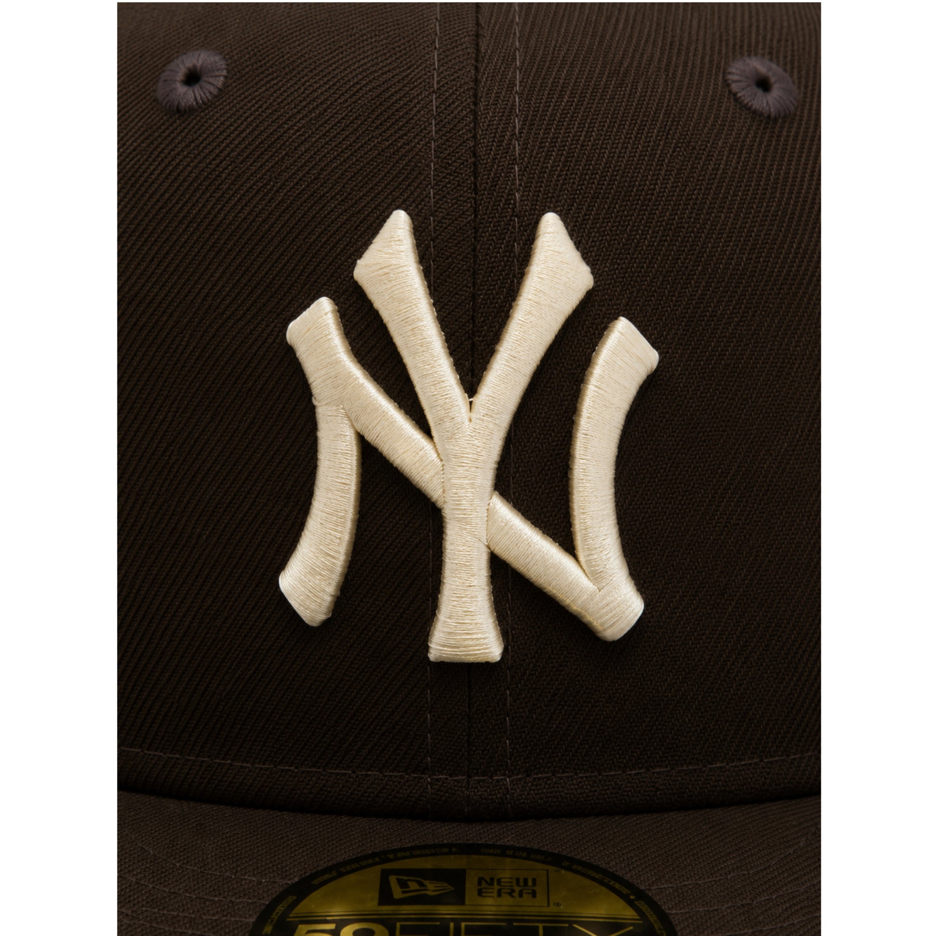 Close-up of a New York Yankees logo on a cap with a dark background
